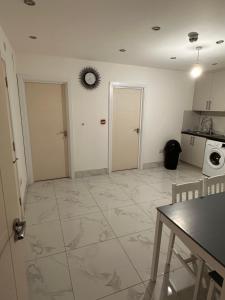 a kitchen with white walls and a tiled floor at Lovely Hillingdon Family Holiday Home - 7 bedrooms in Ickenham