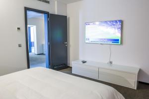 a bedroom with a bed and a tv on the wall at Hotel Tempo in Târgu-Mureş