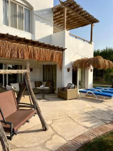 a house with a patio with a chair and a hammock at GS 23 in Hurghada