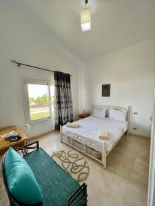 a bedroom with a bed and a couch and a window at GS 23 in Hurghada