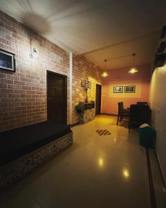 a living room with a couch and a brick wall at Ganga's Sri Balaji Cottage in Ooty