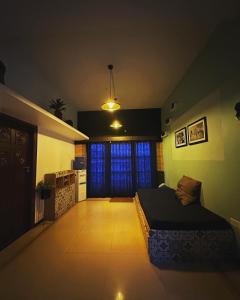 ein Schlafzimmer mit einem Bett in der Mitte eines Zimmers in der Unterkunft Ganga's Sri Balaji Cottage in Udagamandalam