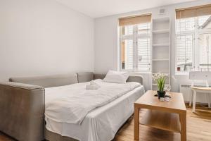 a white bedroom with a bed and a table at Dinbnb Homes I 4-apartment House in Idyllic Location in Bergen