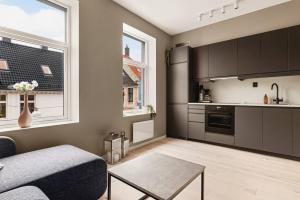 uma cozinha com um sofá e uma mesa num quarto em Dinbnb Apartments I New 2023 I 600m to Bryggen em Bergen
