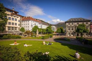 a group of people laying on the grass in a park at Dinbnb Apartments I New 2023 I 600m to Bryggen in Bergen