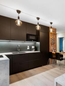 kuchnia z czarnymi szafkami i stołem z krzesłami w obiekcie Dinbnb Apartments I New 2021 I Affordable Option w Bergen
