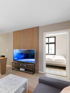 uma sala de estar com uma grande televisão de ecrã plano em Dinbnb Apartments I New 2021 I Affordable Option em Bergen