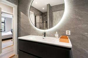 a bathroom with a sink and a mirror at Dinbnb Apartments I New 2021 I Affordable Option in Bergen