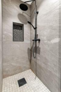 a shower with a glass door in a bathroom at Dinbnb Apartments I New 2021 I Affordable Option in Bergen