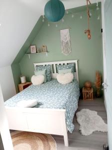 Un dormitorio con una cama blanca con almohadas. en Côte d'Opale - Maison Cocooning Classé 3 Étoiles en Marquise