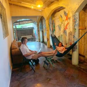 un uomo e un bambino seduti su un'amaca di Stella Hostel Copán a Rovine di Copán