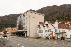 un grand bâtiment blanc sur le côté d'une rue dans l'établissement Dinbnb Apartments I Roof Terrace & Laundry in Sandviken, à Bergen