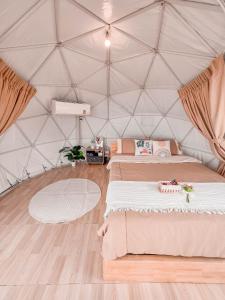 een kamer met 2 bedden in een tent bij ม่อนชาพาเพลิน ม่อนแจ่ม Monchapaplearn Monjam in Mon Jam