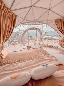 een bed in een tent met een groot raam bij ม่อนชาพาเพลิน ม่อนแจ่ม Monchapaplearn Monjam in Mon Jam