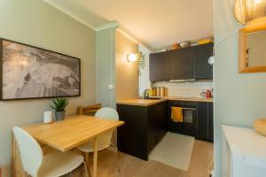 a kitchen with a wooden table and a dining room at Dinbnb Homes I Cozy Cellar Apartment in Historical Cobblestone Street" in Bergen