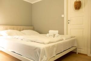 Una cama blanca con dos toallas encima. en Dinbnb Homes I Cozy Cellar Apartment in Historical Cobblestone Street", en Bergen