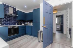 a kitchen with blue cabinets and a blue door at Stunning House near Fort William - Taigh Sona in Spean Bridge +20 photos