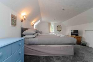 a bedroom with a large bed and a blue dresser at Stunning House near Fort William - Taigh Sona in Spean Bridge