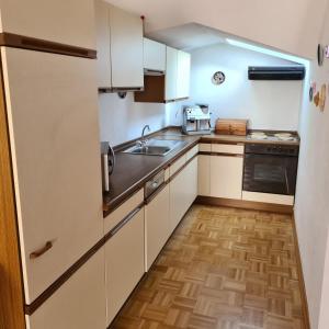 a small kitchen with white cabinets and a sink at Ferienwohnung Sahrmann in Mistelgau