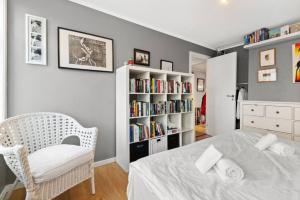 ein Schlafzimmer mit einem Bett und einem Bücherregal mit Büchern in der Unterkunft Dinbnb Homes I Family Friendly Home in Historical Sandviken in Bergen