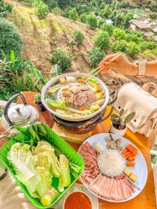 een tafel met borden met voedsel op een tafel bij ม่อนชาพาเพลิน ม่อนแจ่ม Monchapaplearn Monjam in Mon Jam