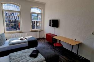 Pokój z 2 łóżkami i stołem oraz 2 oknami w obiekcie Apartment ROTER FADEN w Hanowerze
