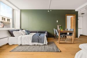 卑爾根的住宿－Dinbnb Apartments I Top-Modern Apartment in Historical Sandviken，一间卧室配有一张床和一张桌子及椅子
