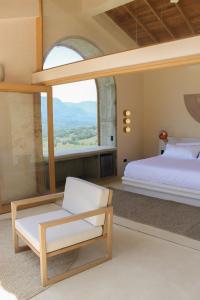 a bedroom with a bed and a chair and a window at Hotel Tahiti in Puente Iglesias