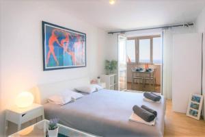 ein Schlafzimmer mit einem großen weißen Bett und einem Tisch in der Unterkunft Light blue, sea view terrace in Dubrovnik