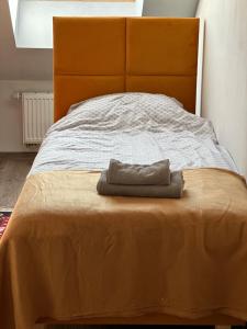 a bed with a blanket and a hat on it at Apartament Oksford 2 in Okszów
