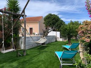 a yard with two chairs and a hammock at Casas Bemposta in Monchique