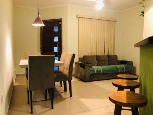 a living room with a couch and a table and chairs at Casa Spar do Atlântico com Piscina in Maricá