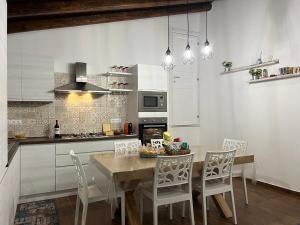 a kitchen with a wooden table and white cabinets at Chiarilu' in Palazzolo Acreide