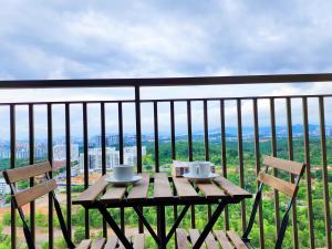 einen Holztisch und Stühle auf einem Balkon mit Aussicht in der Unterkunft D'Hive By Tiara Imperio in Kajang