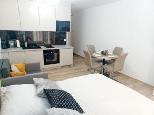 a room with a bed and a table and a kitchen at AJP Gold Szczecin Dąbie in Szczecin