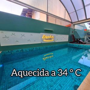 a swimming pool in a building with a sign on it at Belle Arti Pousada in Florianópolis