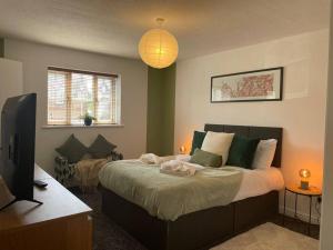 a bedroom with a large bed and a television at Ramson's Homestead by M-GroupSA in Cardiff