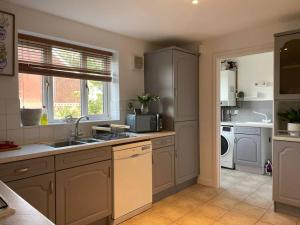 eine Küche mit einer Spüle und einer Mikrowelle in der Unterkunft Ramson's Homestead by M-GroupSA in Cardiff