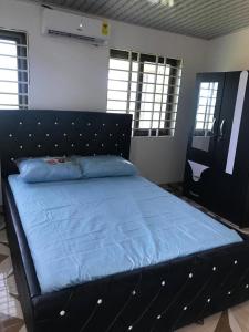 sypialnia z łóżkiem z niebieską narzutą w obiekcie Holly House w mieście Oshien