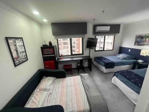 a bedroom with a bed and a desk and a bed and a room at LFlats no Hotel Aeroporto Congonhas in São Paulo