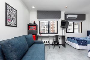 a living room with a couch and a bed at LFlats no Hotel Aeroporto Congonhas in Sao Paulo