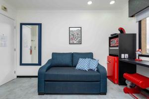a living room with a blue chair and a television at LFlats no Hotel Aeroporto Congonhas in Sao Paulo +215 photos