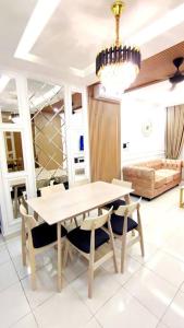 uma sala de jantar com uma mesa e cadeiras e um lustre em Luxury Suite Alanis Residence Sepang KLIA1 KLIA2 Putrajaya Cyberjaya em Sepang