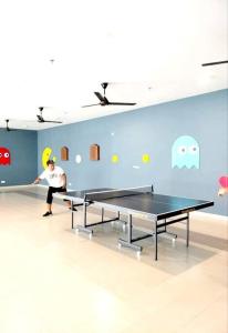 una persona che gioca a ping pong in una stanza con due tavoli da ping pong di Luxury Suite Alanis Residence Sepang KLIA1 KLIA2 Putrajaya Cyberjaya a Sepang