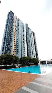 um grande edifício de apartamentos com uma piscina em frente em Luxury Suite Alanis Residence Sepang KLIA1 KLIA2 Putrajaya Cyberjaya em Sepang
