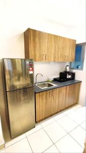 uma cozinha com um frigorífico de aço inoxidável e um lavatório em Luxury Suite Alanis Residence Sepang KLIA1 KLIA2 Putrajaya Cyberjaya em Sepang