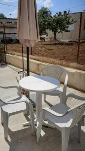 un tavolo e due sedie e un ombrellone di Suburban Oasis a Alexandroupoli