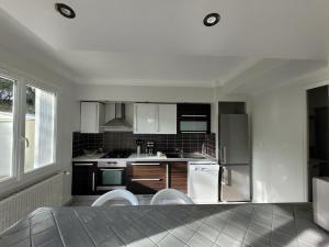 a kitchen with black and white cabinets and appliances at Studio lit double. in Gréoux-les-Bains