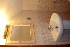 a bathroom with a mirror and a sink and a urinal at Casa Mamica Rosario in Yegen