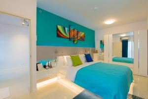 een slaapkamer met een bed en een blauwe muur bij W Phuket in Phuket